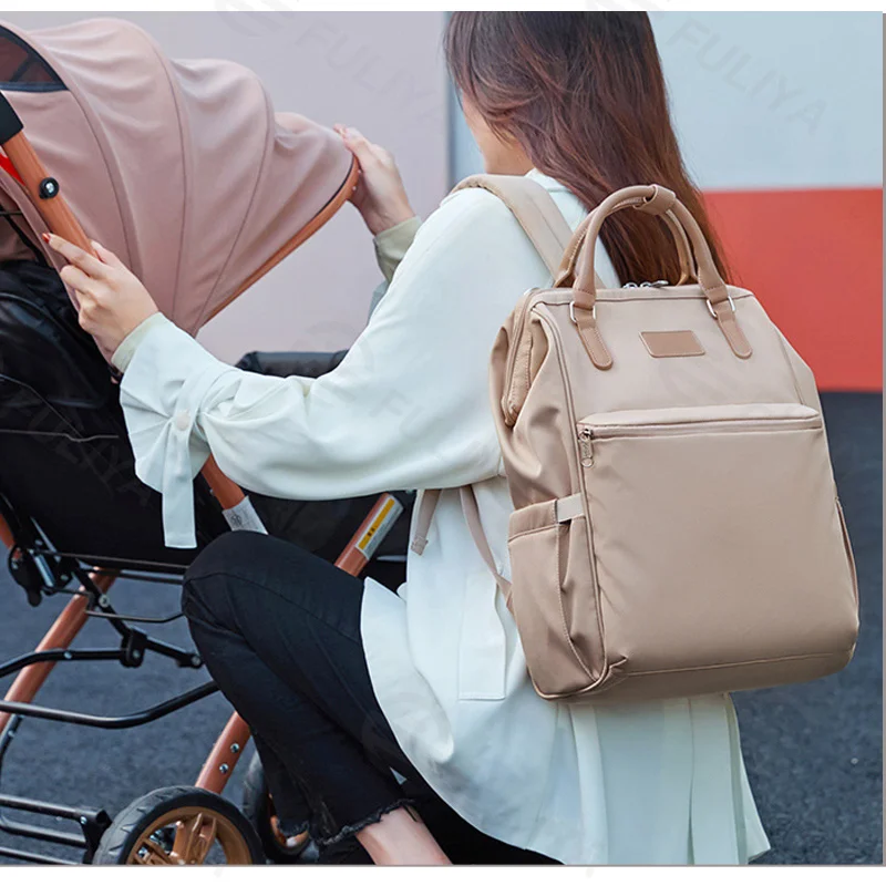 Guangzhou Fuliya Industry Co.,Ltd C-81322 Lightweight mommy backpack, water-repellent fabric, wide-opening main compartment, wet/dry separation, foil-insulated bottle pocket, tissue pocket, and luggage sleeve - for baby outings and daily use.