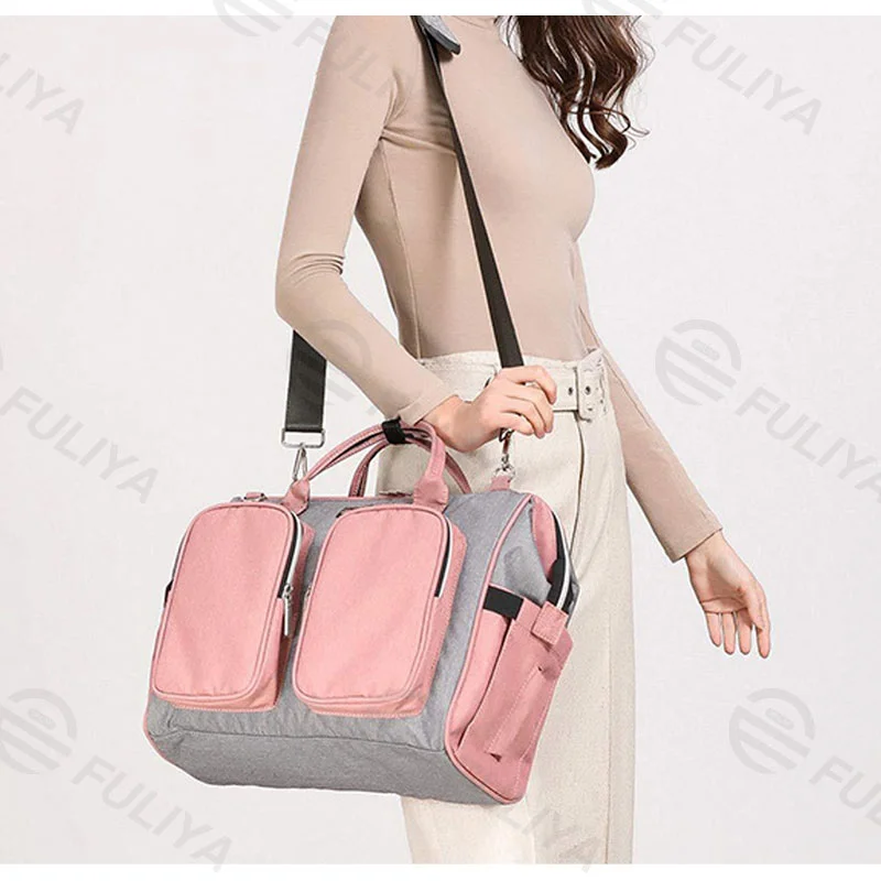 Guangzhou Fuliya Industry Co.,Ltd C-80802 Waterproof large-capacity diaper tote bag, supports hand/shoulder/crossbody carry. Features stroller hooks, front pockets, and a changing pad. For baby daily travel.